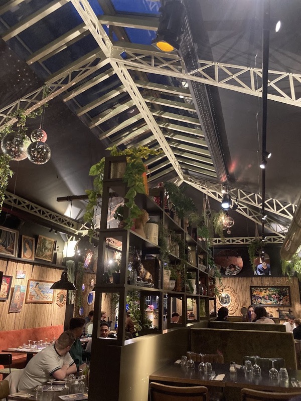 Verrière et mezzanine du restaurant avec plantes suspendues